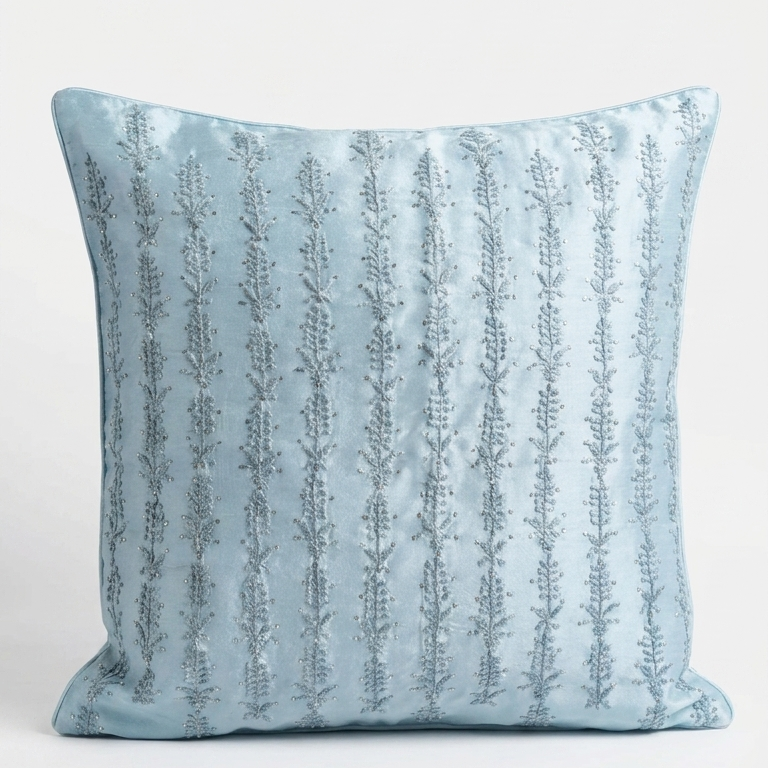 A square Chikankari embroidered light blue cushion pillow with vertical textured stripes, shown against a plain white background.