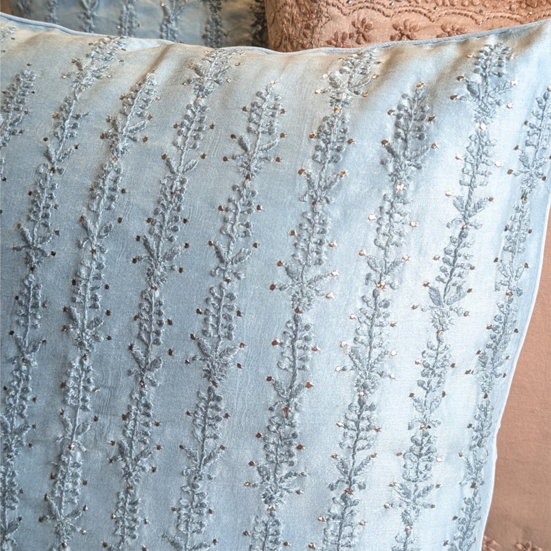 Close-up of a light blue chikankari cushion cover intricate pattern.