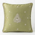 An olive green Chikankari throw pillow with a white embroidered central teardrop motif and small scattered star-like embroidery, set against a plain white background.