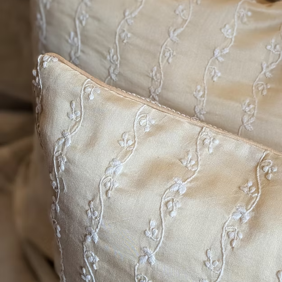 Close-up of beige fabric with intricate white embroidery
